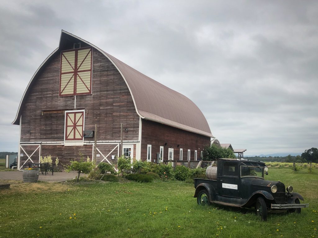 large barn with old car in front