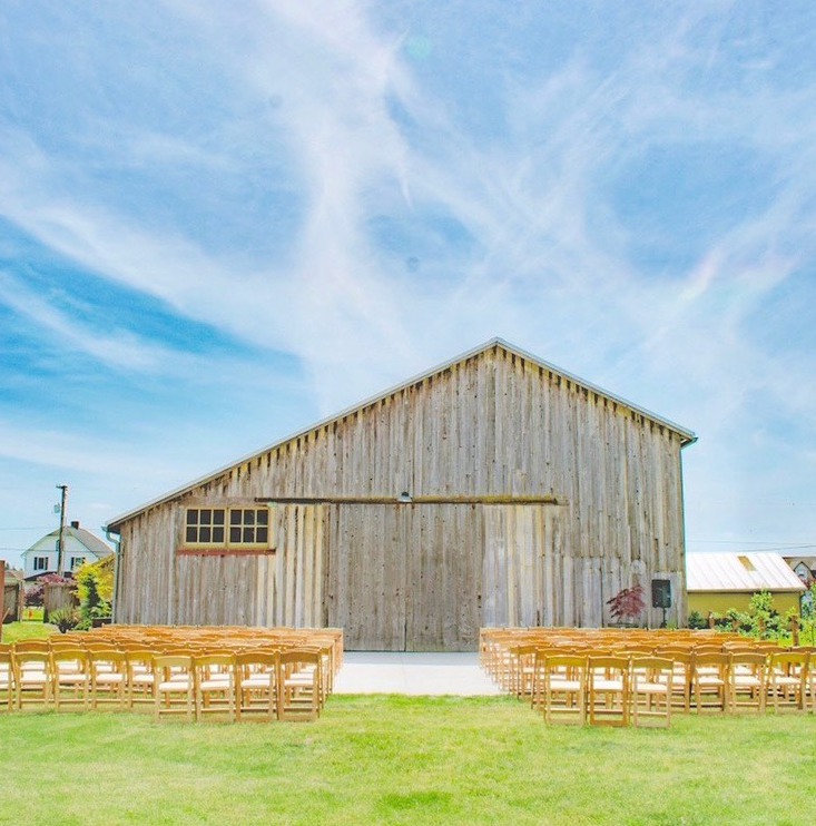 barn with chairs in front, set up for a wedding