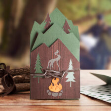 A handcrafted paper greeting card showing a campfire scene.